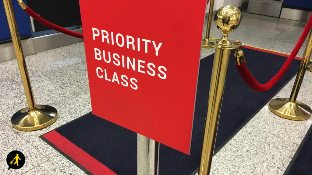 A sign for priority business class with velvet ropes.