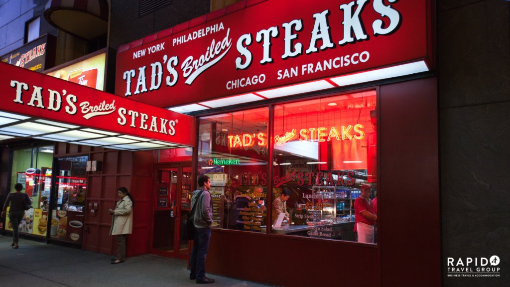 A restaurant in the US called 'Tad's Broiled Steaks' with red signs and white writing. It advertises that it has restaurants in Chicago, San Francisco, New York and Philadelphia.