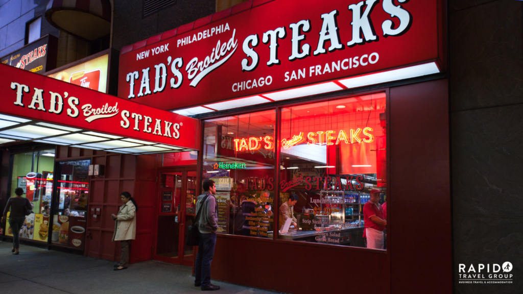 A restaurant in the US called 'Tad's Broiled Steaks' with red signs and white writing. It advertises that it has restaurants in Chicago, San Francisco, New York and Philadelphia. 