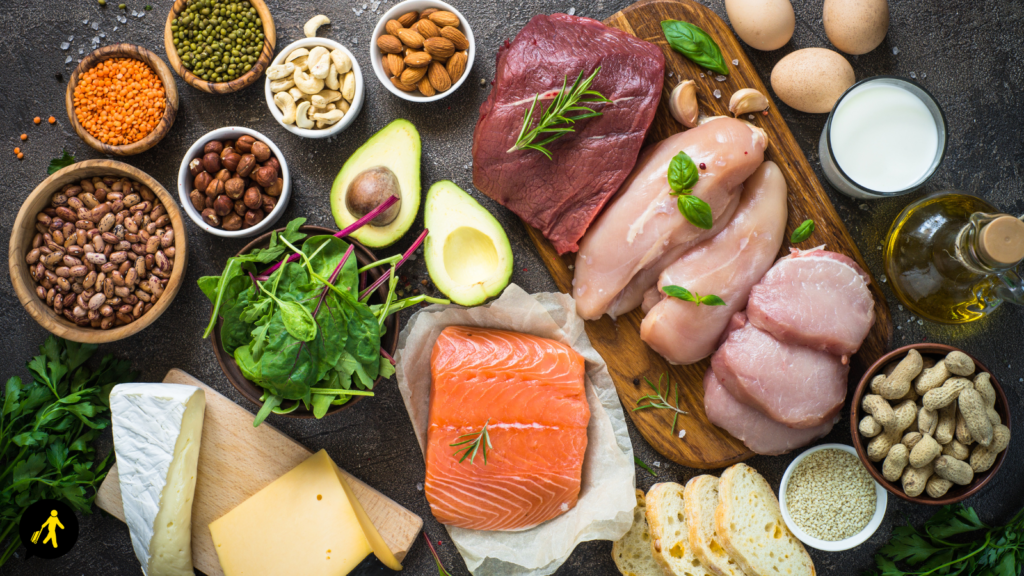 A display of protein-rich foods, including salmon, avocado, eggs, almonds, peanuts, lentils, cheese, chickpeas, cashew nuts and various meats.