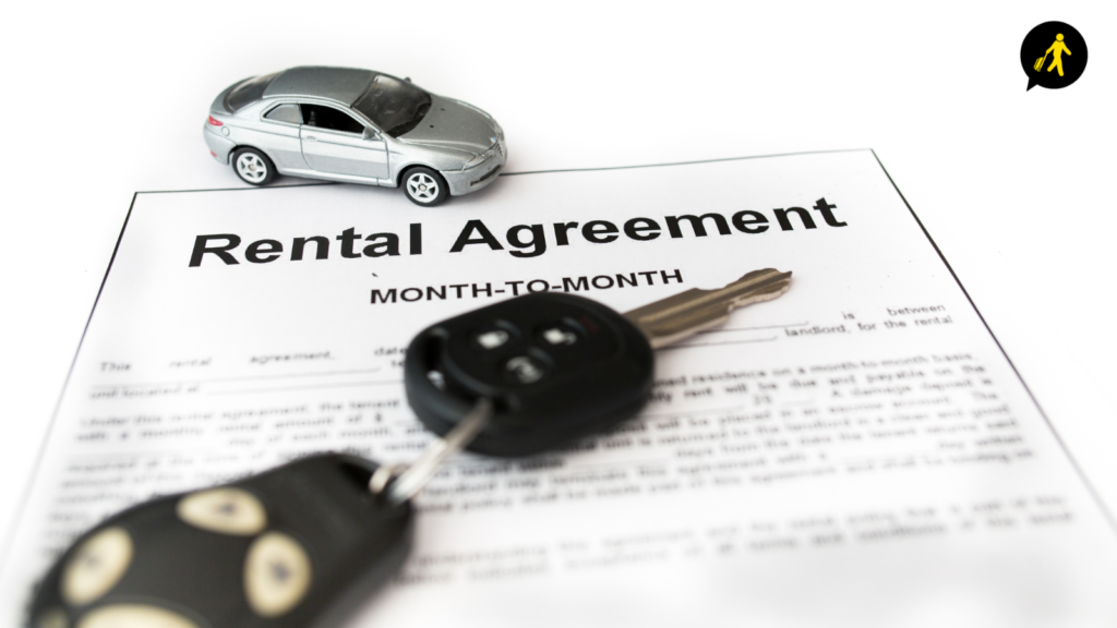 Car hire rental agreement with the car keys on top and a small grey toy car.