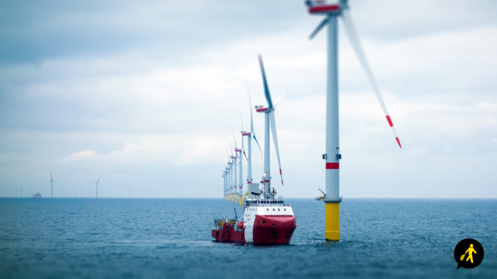An offshore wind farm with a boat next to the nearest turbine.