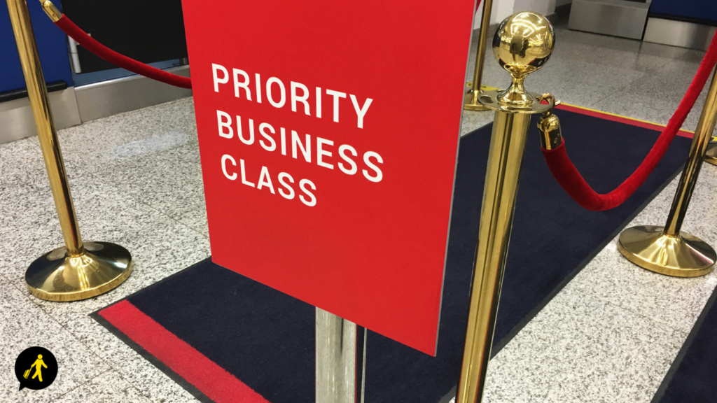 A sign for priority business class with velvet ropes. 
